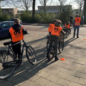 Leerlingen stappen op hun fiets voor het praktijkexamen.