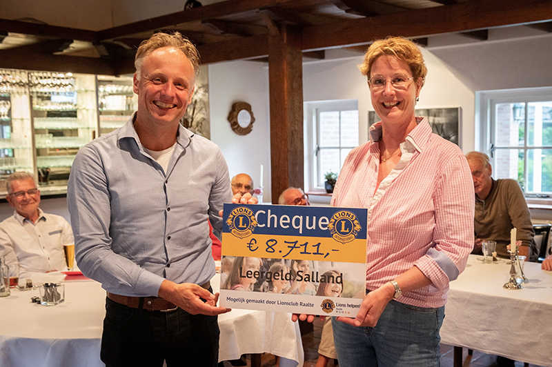 Robert Nijkamp overhandigt de cheque aan Carola Beumer van Leergeld Salland